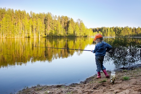 Baby on the lake fishing.の写真素材