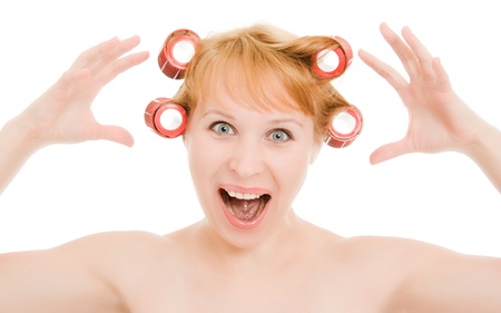 Woman in curlers moans on a white background.の写真素材