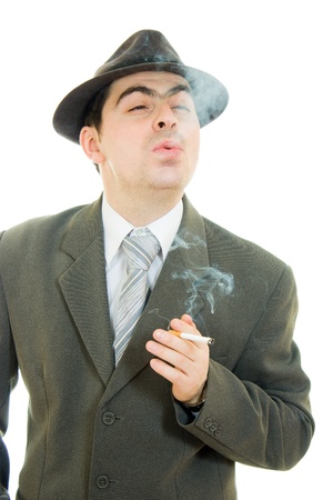 A businessman in a hat smokes on a white background.の写真素材