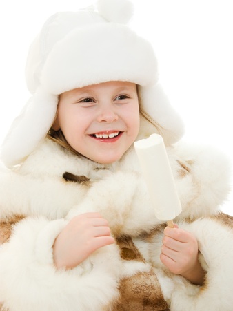 The girl in warm clothes eating ice cream on white background.の写真素材