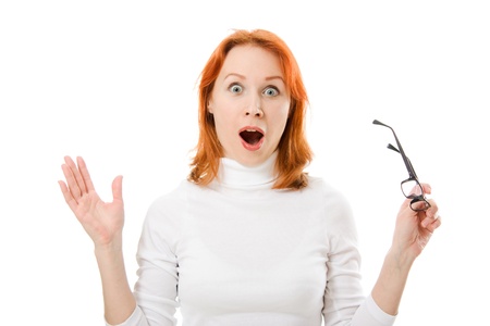 A beautiful girl with red hair wearing glasses was surprised on a white background.の写真素材
