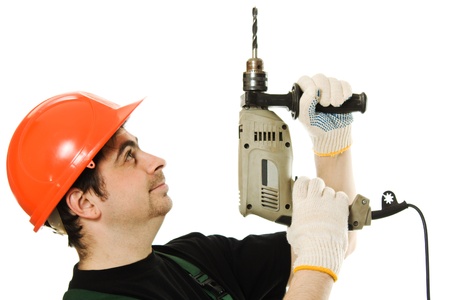 Male worker with an electric drill on a white backgroundの写真素材
