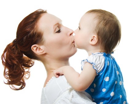 Mother kissing her daughter on a white backgroundの写真素材