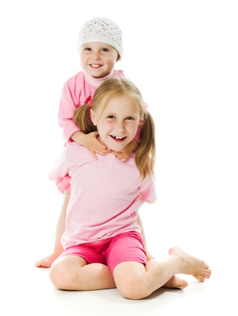 Big sister, little sister hugging on a white background.の写真素材
