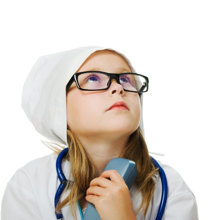 Cute little girl is playing doctor with stethoscope, isolated over whiteの写真素材
