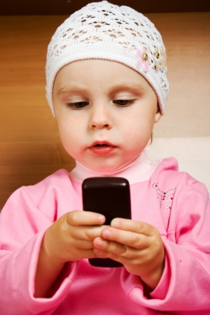 Sweet small baby with mobile phone close-up.の写真素材