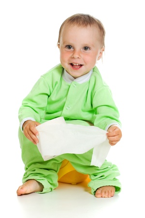 Child on potty play with toilet paper, isolated over whiteの写真素材