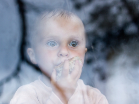 young baby looking from window on the other sideの写真素材