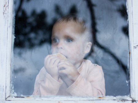young baby looking from window on the other sideの写真素材