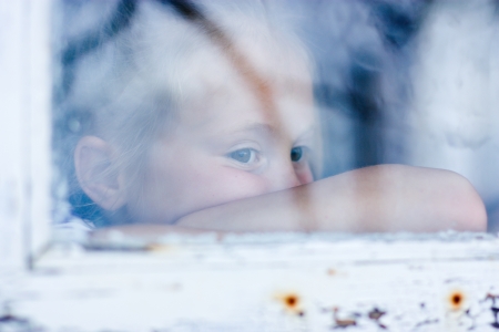 young girl looking from window on the other sideの写真素材