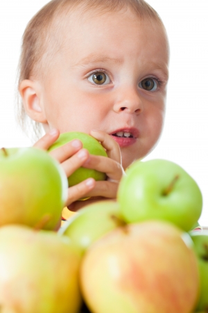 Baby eating apple on a white background.の写真素材
