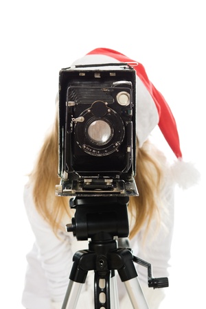 Girl in a Christmas costume with old camera on a white background.の写真素材