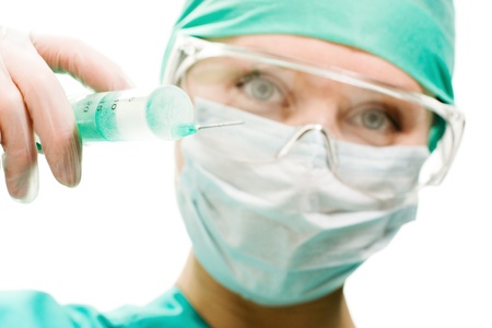 Surgeon woman with syringe making injection, on a white background.の写真素材