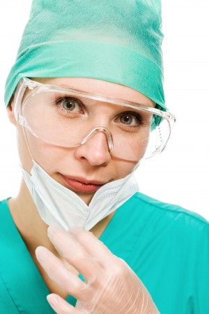 Surgeon woman in protective glasses and mask on whites background.の写真素材