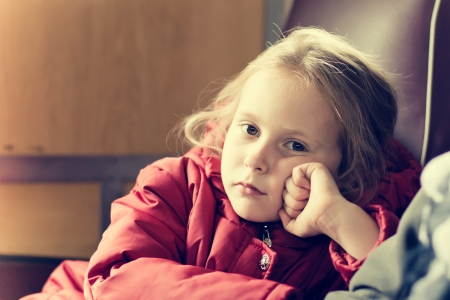 Girl rides on a train sitting in a chair.の写真素材