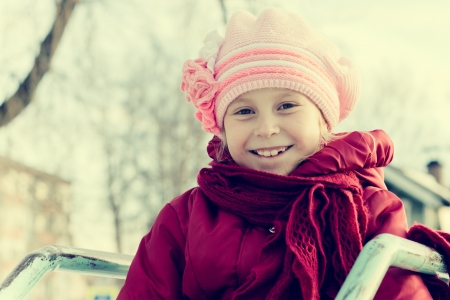 Young girl walking outdoors on the playground in a retro style.の写真素材