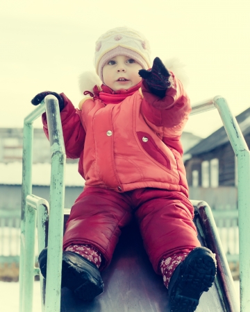 Small child is riding a roller coaster on the playground in a retro style.の写真素材