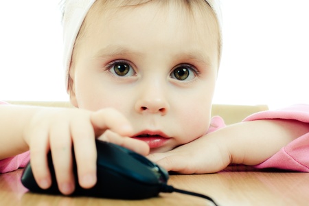 Cute baby looking into the laptop on a white background.の写真素材