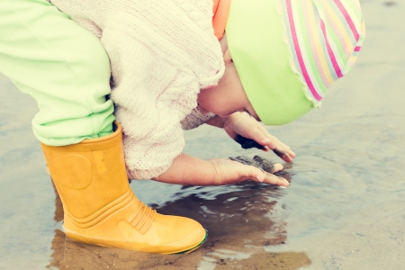 Baby washes up in a muddy puddle.の写真素材