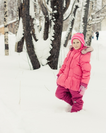 Beautiful happy girl in the red jacket winter outdoors.の写真素材