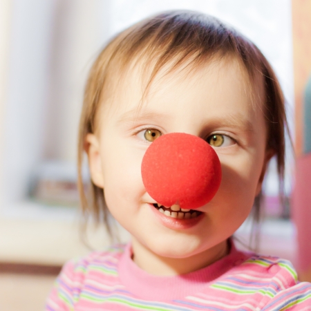 Kid with red nose clown fooling around.の写真素材