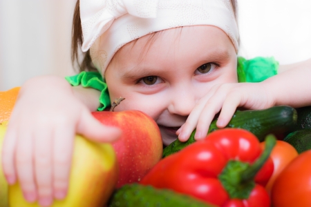 Happy Kid with vegetables and fruits sitting at the table.の写真素材
