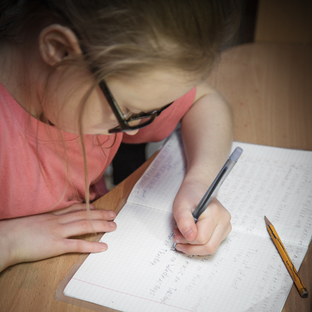 Portrait girl make written lessons at home.
