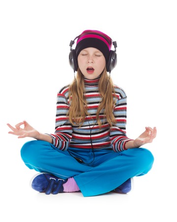 Girl with headphones listening to music on a white background.の写真素材