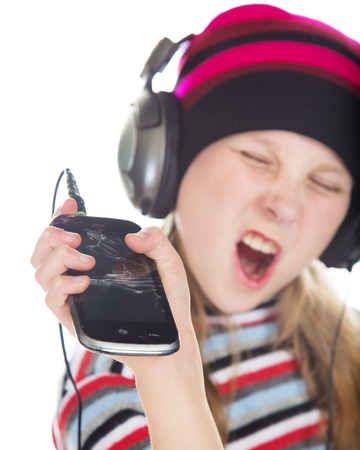 Girl with headphones listening to music on a white background.の写真素材
