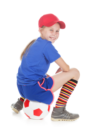 Beautiful girl in a sports cap and a T-shirt with a ball on a white background.の写真素材