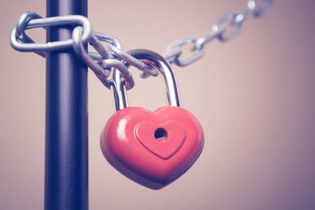 Lock in the form of a heart hanging on a chain. Photos in retro style.の写真素材
