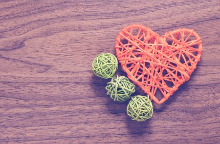 Wicker heart handmade with lying on a wooden background.の写真素材