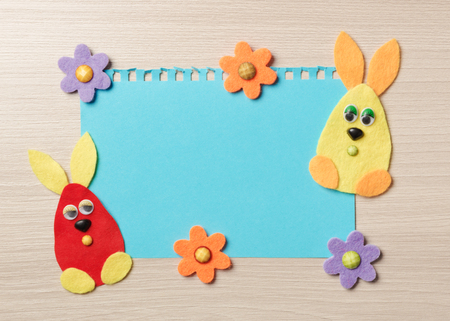 Happy easter bunny and of felt c sticker paper on a wooden background.の写真素材