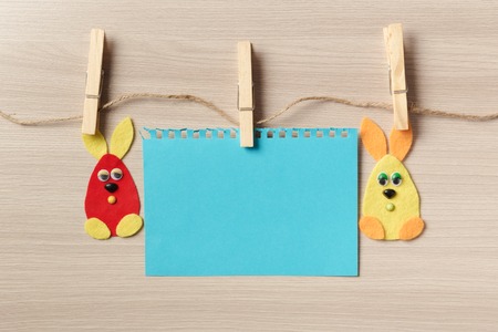 Two Easter bunny on the clips to a rope on a wooden background.の写真素材