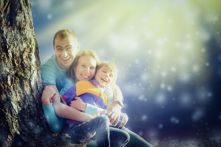 Mother father and daughter playing outdoors in the bright sun.の写真素材