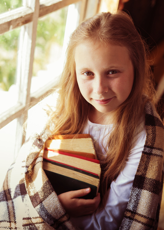 Young beautiful girl with books by the window.の写真素材