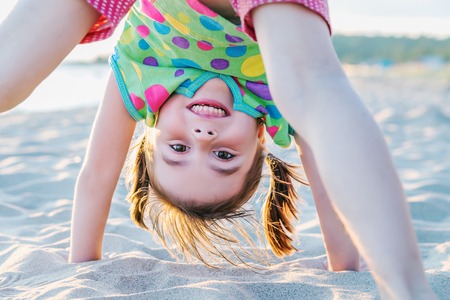 Happy little girl having fun on the beach.