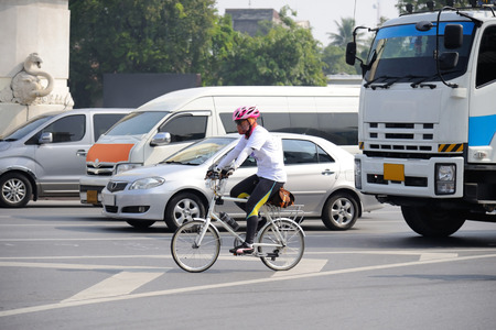 Unidentified cyclist riding his bicycle on Bangkok roadの写真素材