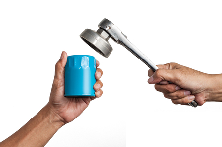 Car mechanic hold an oil filter and a ratchet wrench in his hand isolated on white backgroundの写真素材