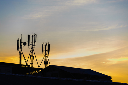 Silhouette cellular antennas at sunriseの写真素材