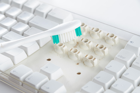 Disassemble and clean up a dirty white keyboard with a toothbrush.の写真素材