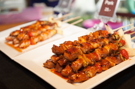 Thai street food BBQ, Pork satay skewer topped with sauceの写真素材
