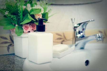 Lotion bottle in a bathroom. Dispenser cream bottle and soap on a wash basinの写真素材