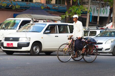 Yangon, Myanmar - Feb 13, 2018: Myanmar taxi and bicycle taxi on a road of Yangon, Myanmarのeditorial素材