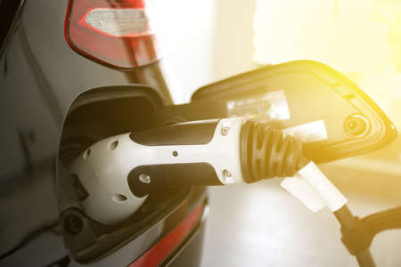 Close up of power supply plugged into a electric vehicle. New era of green envirornment
