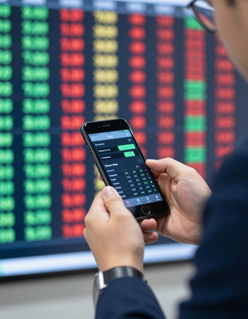 Businessman using mobile smart phone with stock market graph on the background