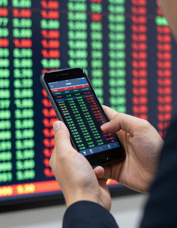 Businessman using a smart phone with stock exchange data on the screen