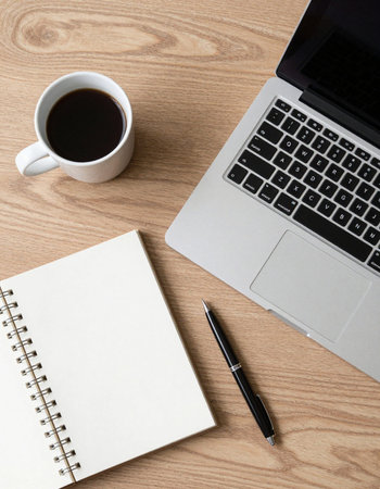 Office desk table with laptop, coffee cup and notebook. Top view with copy space. Flat lay.