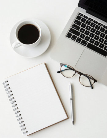 White office desk table with laptop, coffee cup and notebook. Top view with copy space. Flat lay.