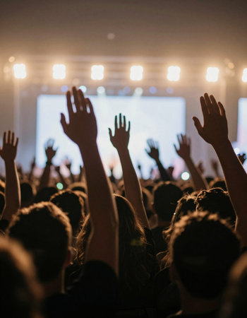Crowd cheering at a live concert with hands raised in the air